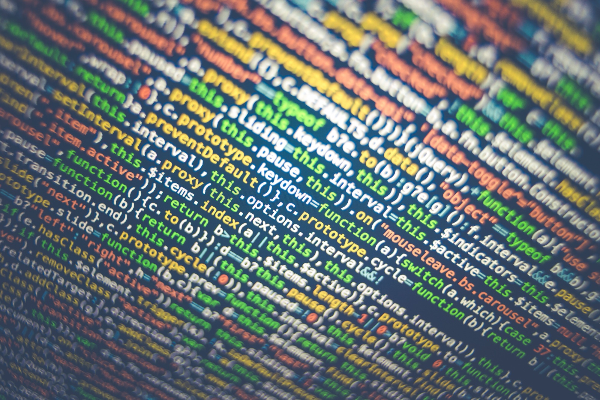 Computer screen displaying code in a dark room