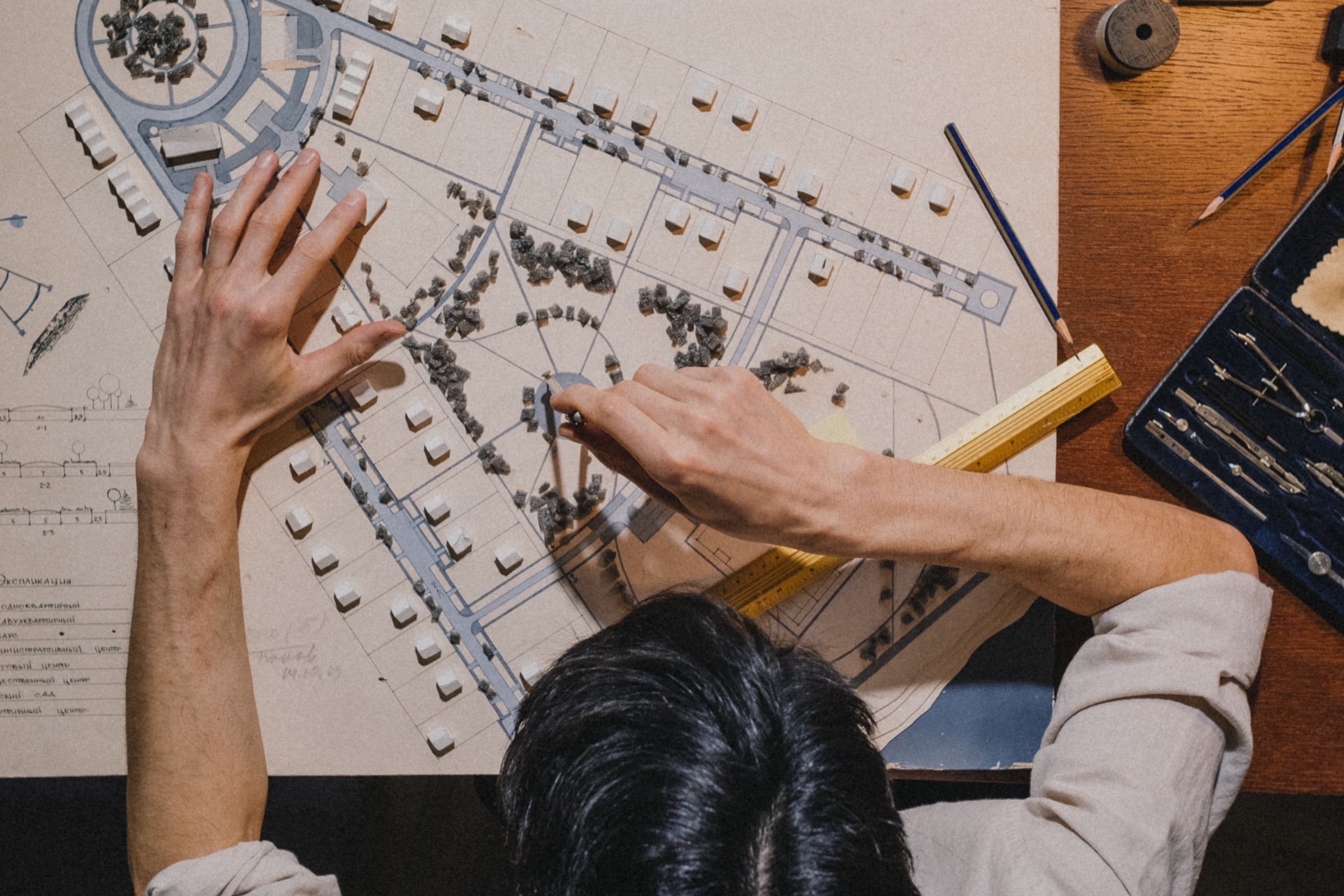 Someone at a drafting table sketching a site plan for a corporate campus